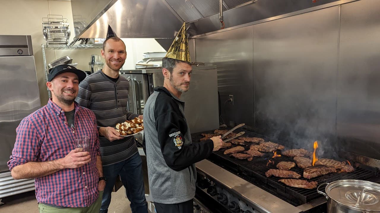 Dads grilling steaks in the kitchen at a Dad's Club event